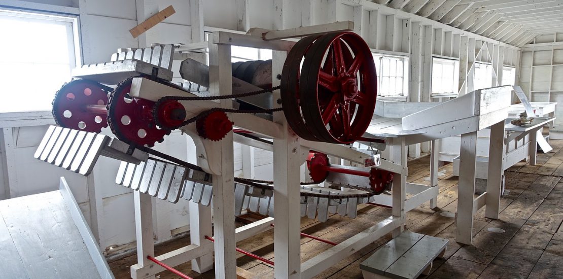 A small manufacturing automation machine in an older factory with wood floors.