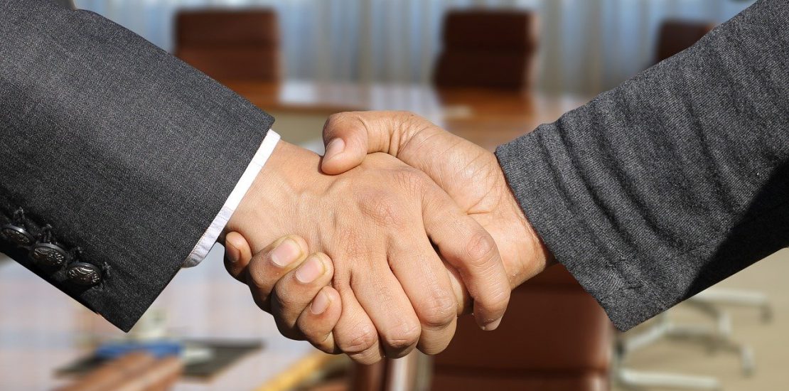 Two men in suits shaking hands. Don't fall in love with the deal.